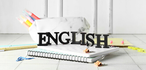 Word ENGLISH and stationery on light table