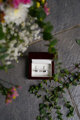 Two silver wedding rings. Women's with zircons and men's without. In a wooden box lined with white...