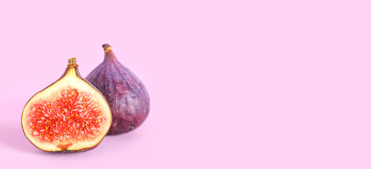 Fresh juicy cut figs on lilac background
