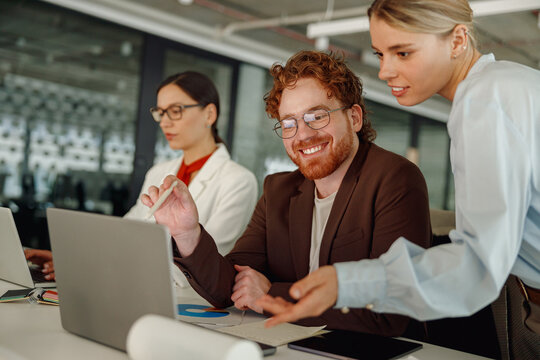 Diverse team members collaborate on an exciting project in a modern workspace, showcasing teamwork and creativity