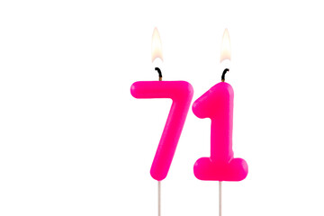Pink number 71 birthday candle lit on white background