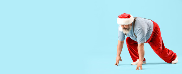 Sporty Santa Claus getting ready to run on blue background