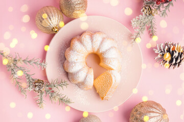 Plate with tasty Christmas cake and decorations on pink background