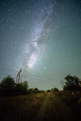 Space with galaxy . Milky way on the blue sky .Dark and cold night at summer . Trees on the backgound with stars . Power lines in the night , powerstation and galaxy