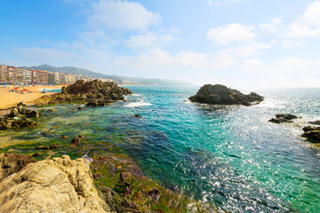 View from a hilltop trail near Cala Banys beach of the Platja de Lloret de Mar, the wide sandy beach at the Costa Brava town of Lloret de Mar, Spain.	