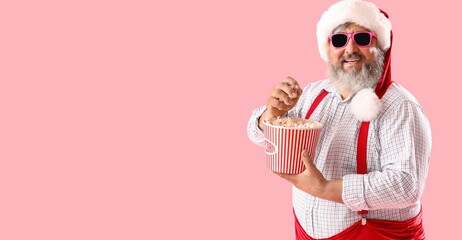 Santa Claus eating popcorn on pink background with space for text