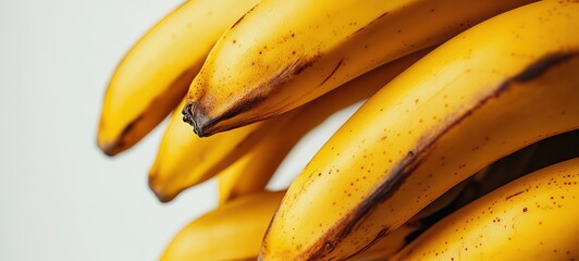 A bunch of ripe bananas with their bright yellow peels, displayed against a white background