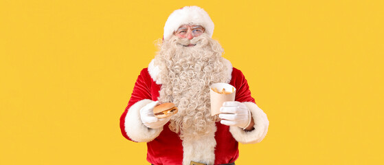 Santa Claus with tasty burger and french fries on yellow background