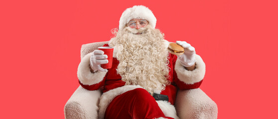 Santa Claus with cup of tea and tasty burger in armchair on red background