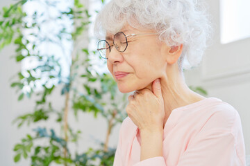 喉が痛いシニア女性　リビングルーム © siro46