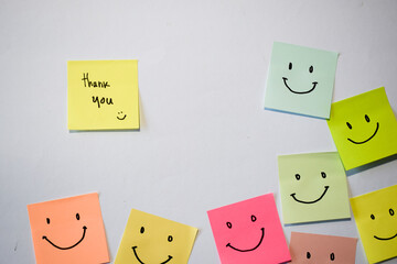 Thank you and smile emoticon on sticky notes. Motivational for personal development, inspirational handwriting. Isolated background