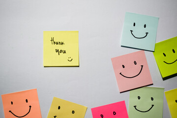 Thank you and smile emoticon on sticky notes. Motivational for personal development, inspirational handwriting. Isolated background