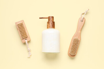 Soap dispenser with brushes on orange background