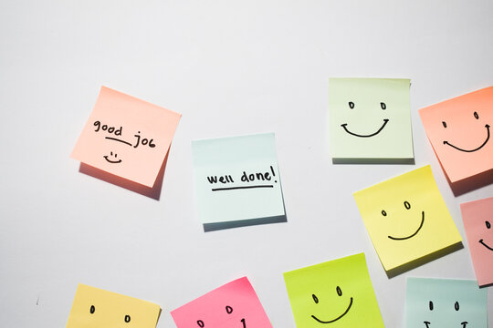 Good Job and well done with smile emoticon on sticky notes. Motivational words for personal development, inspirational handwriting. Isolated on background