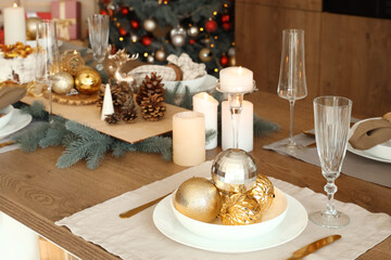 Christmas setting with burning candles on dining table in kitchen, closeup