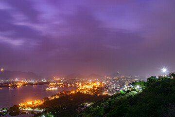 Udaipur city palace illuminating the night with a beautiful purple sky in rajasthan india