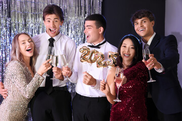 Group of young people with champagne and figure 2024 at Christmas party