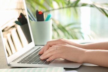 Woman using modern laptop at table in office