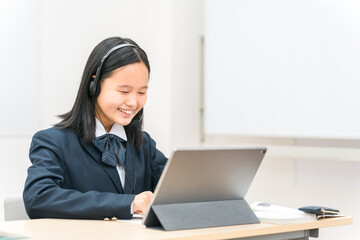 タブレットを使って勉強する制服姿の小学生・中学生・高校生の子供（ICT教育・授業・生徒）
