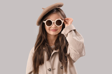 Little girl in sunglasses on light background