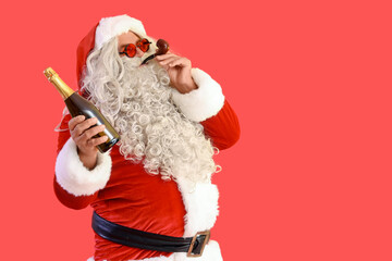 Santa Claus with smoking pipe and bottle of champagne on red background