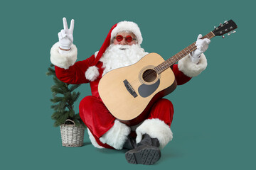 Cool Santa Claus with Christmas tree and guitar showing victory gesture on green background