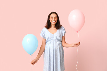 Beautiful happy pregnant woman with balloons on pink background. Gender reveal party concept