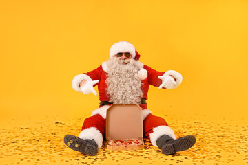Cool Santa Claus pointing at tasty pizza on yellow background