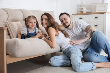 Obraz premium Happy family. Parents and their cute little daughter on sofa at home