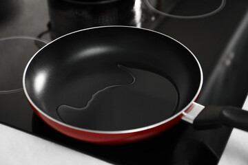 Frying pan with oil on cooktop in kitchen, closeup