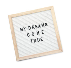 Letter board with phrase My dreams come true on white background, top view