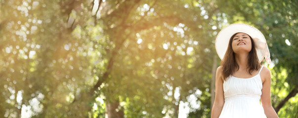 Banner Portrait Asian Woman relaxing in green park. Happy Relax asian woman smiling face at...