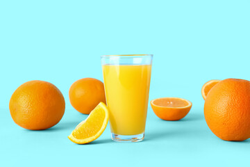 Glass of fresh orange juice on blue background