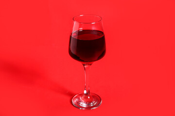 Glass of wine on red background