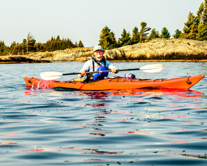 young man paddling on a multiday sea kayak expedition on  georgian bay ontario  room for text