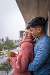 Fototapeta premium Young couple in love sharing a tender moment on balcony