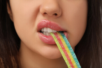 Young woman eating sweet candy, closeup