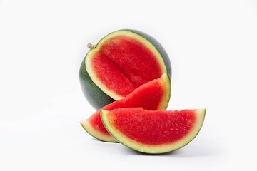 Whole watermelon and seeded slices seen front and top on a white background. Watermelon slices are red, seedy and juicy.