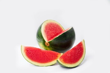Whole watermelon and seeded slices seen front and top on a white background. Watermelon slices are red, seedy and juicy.