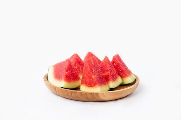 Whole watermelon and seeded slices seen front and top on a white background. Watermelon slices are red, seedy and juicy.