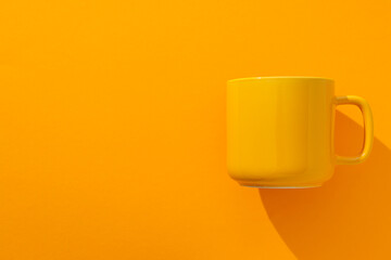 A yellow cup on a yellow background