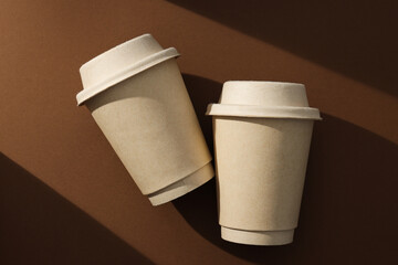 Paper cups with lids on a brown background