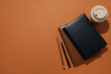 Black and brown notebooks with a cup of coffee