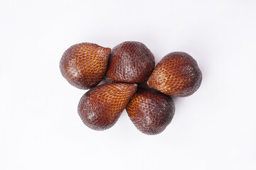 Snake fruit isolated on white background. one of which has its skin opened halfway. Snakefruit, also known as salak (Salacca zalacca), is a distinctive fruit native to Southeast Asia.