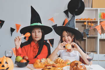 friendship, holiday and people concept - group of happy smiling friends in halloween costumes of vampire, devil, witch and cheetah at home party