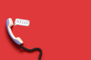 Lilac retro telephone handset and speech bubble with text HELLO on red background