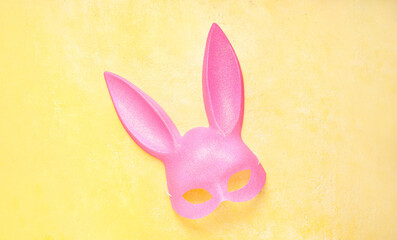 Pink bunny mask on yellow grunge background