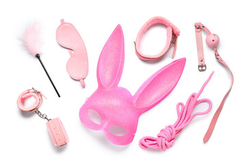 Pink bunny mask with sex toys on white background