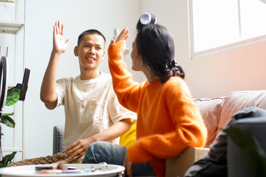 Asian Beauty Influencer And Her Assistant Giving High Five Before Recording Video For Social Media - Powered by Adobe