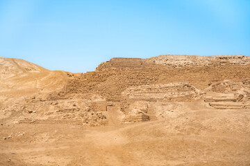 A view of the ancient ruins at Pachacamac, Peru, showcasing historical architecture and archaeological significance under a clear blue sky.